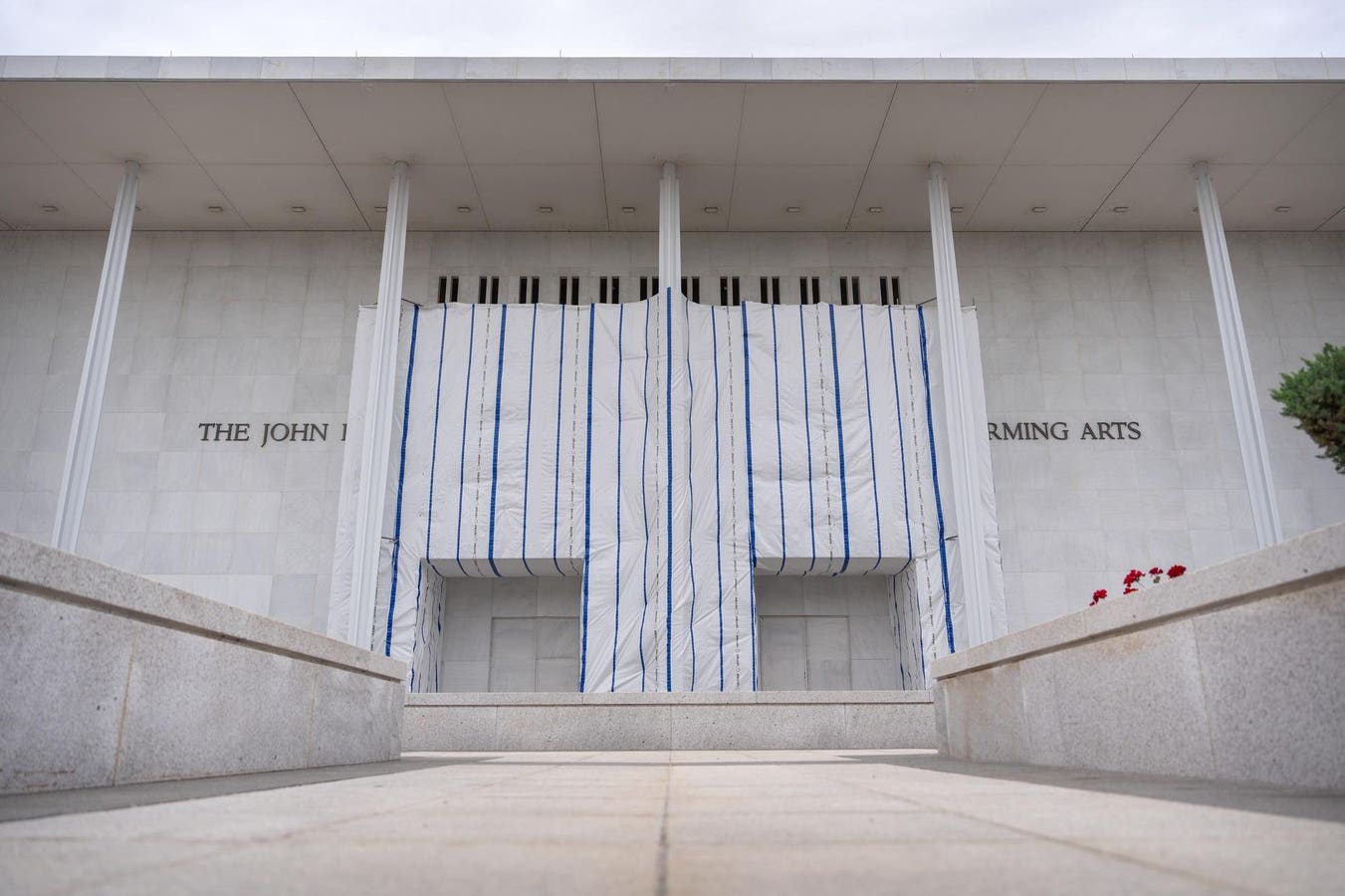 The Kennedy Center says President Donald Trump’s name was taken off the building’s facade, but a tarp has prevented onlookers from seeing it for thems